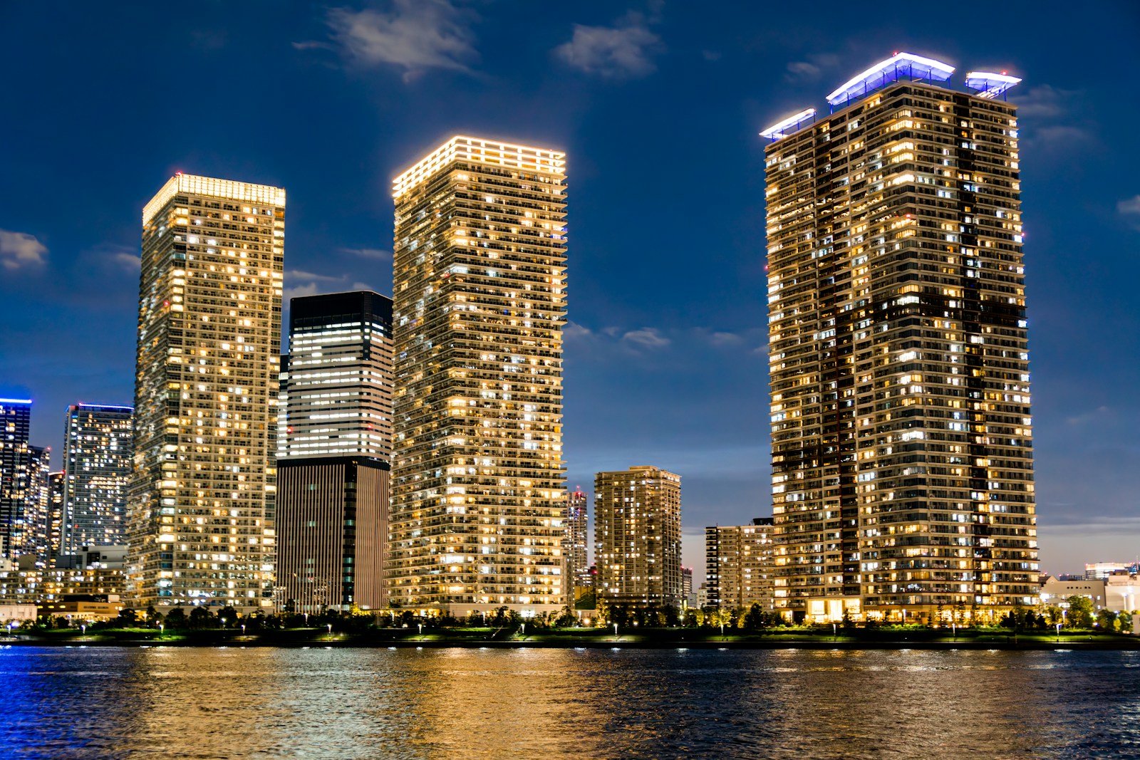 a group of tall buildings next to a body of water